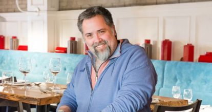 Kevin connell owner of maison fou smiling at the camera.