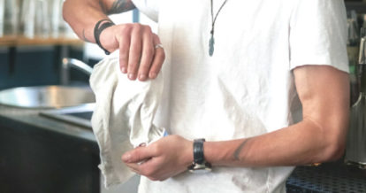 Barback polishing glasses behind a bar