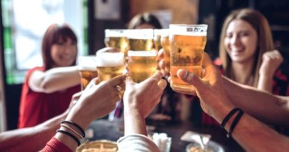 Friends around a table raising their glasses