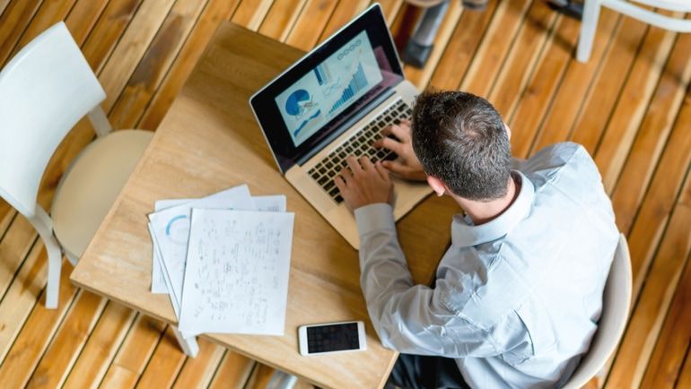 A man checking restaurant analytics on a laptop