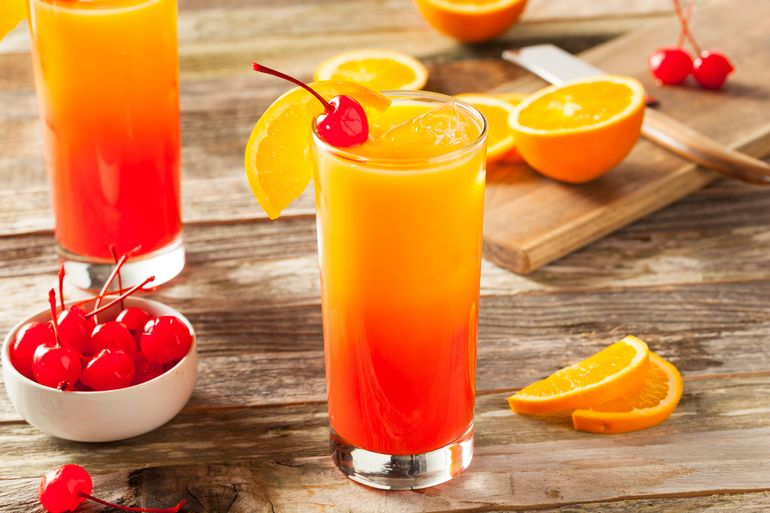 Orange and red wells drinks topped with a red cherry and oranges.