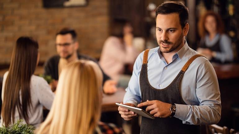 server taking an order with a POS tableside