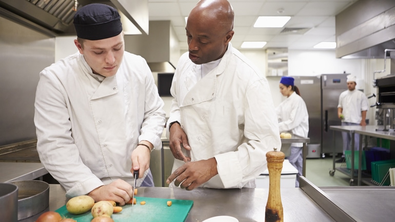Chef helping train a new employee