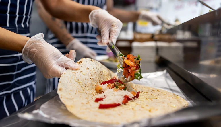 Fast food restaurant staff preparing wraps.