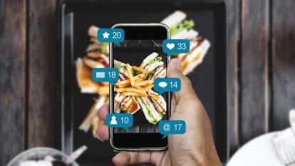 Image of someone using social media while capturing a photo at a restaurant.